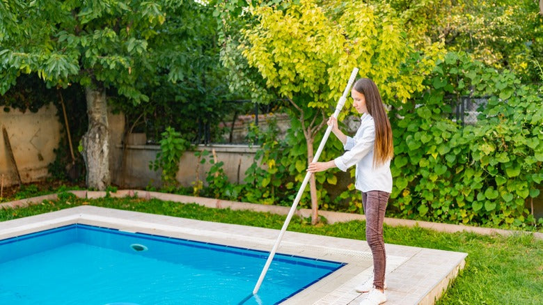 manually vacuuming a swimming pool