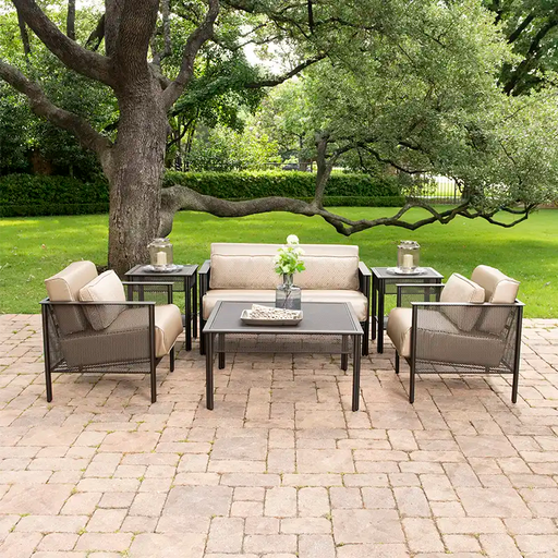 wrought iron mesh outdoor sofa set sitting under a tree on a brick patio